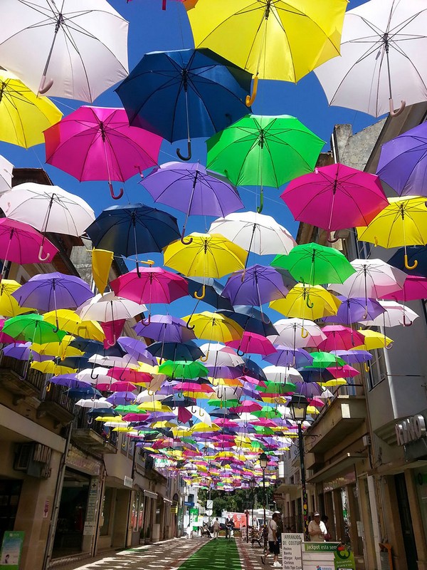 Разноцветные зонтики над улицами в Португалии 